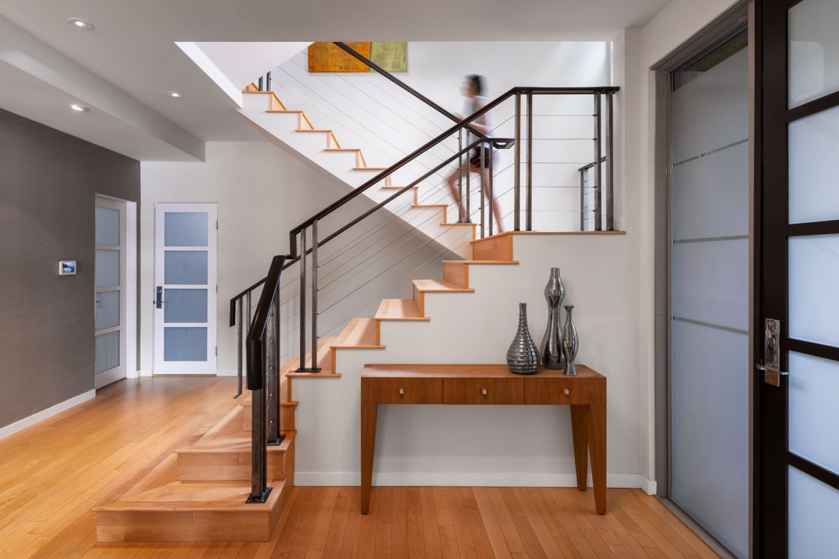 Architectural interior of contemporary entryway with model walking up staircase