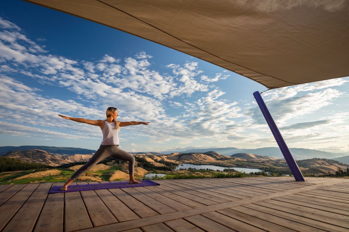 Yoga lifestyle model on yoga platform at Predator Ridge Resort near Vernon with beautiful landscape