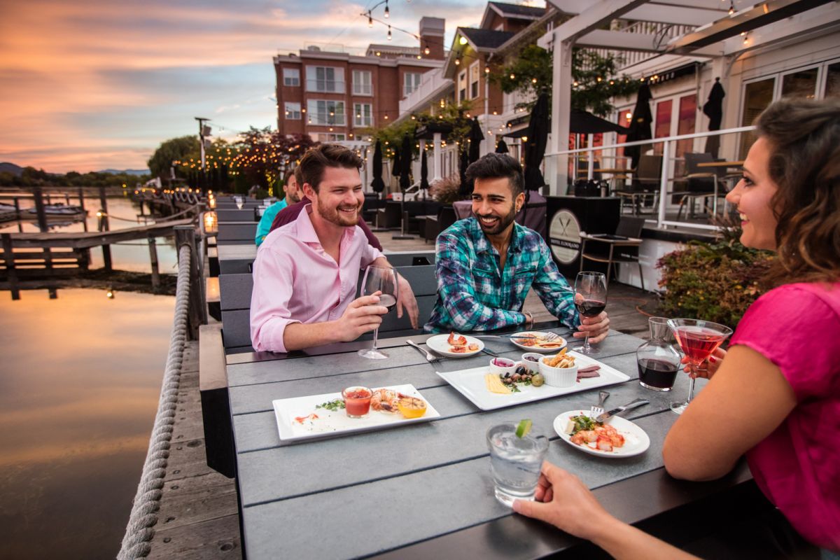 Tourism Kelowna hotel restaurant patio boardwalk with people eating lakeside
