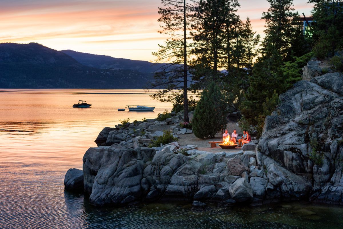 couples sit by campfire at sunset on Okanagan Lake at Outback Resort near Vernon BC