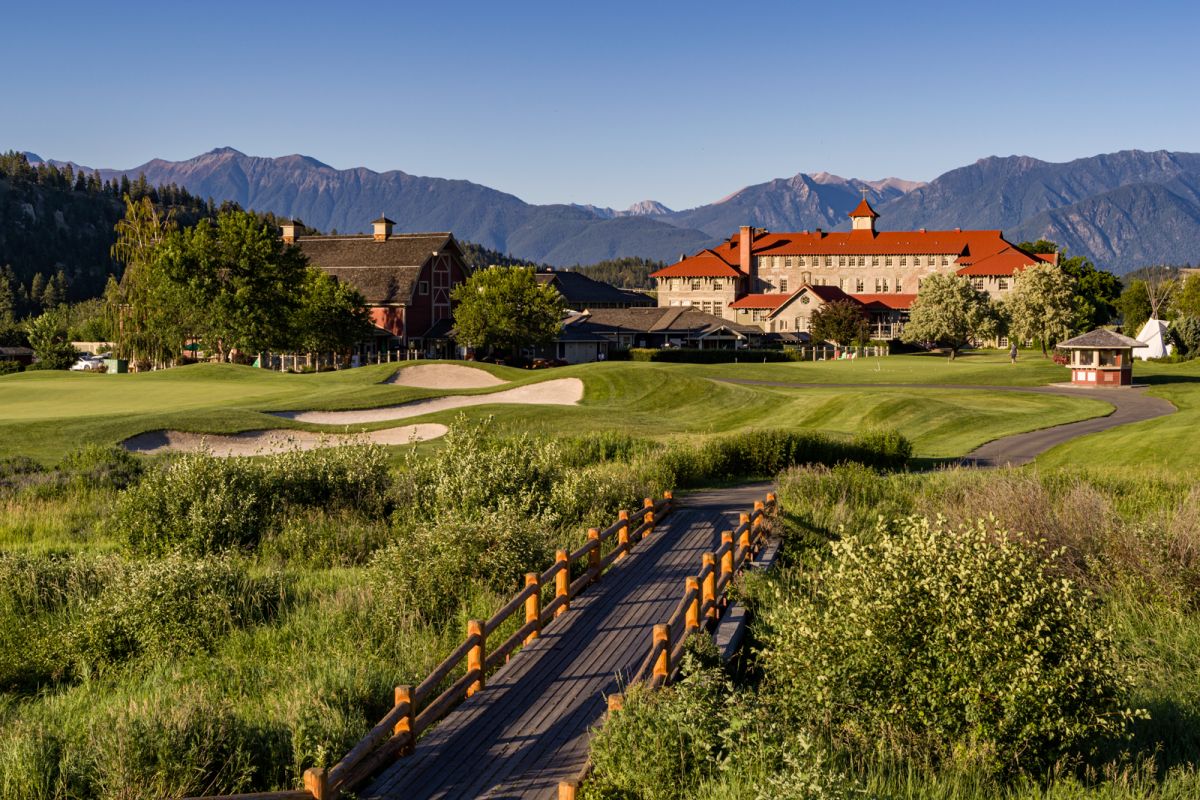 Aerial photograph across golf course of St Eugene Resort in Cranbrook, BC with Rocky Mountains in background