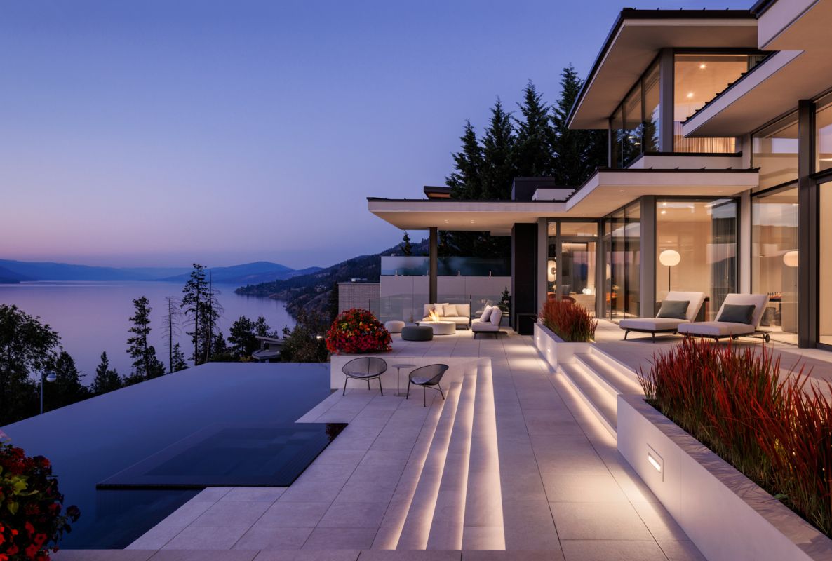 Architectural photograph by Shawn Talbot of luxury mansion's infinity pool deck and patio overlooking Okanagan Lake at dusk