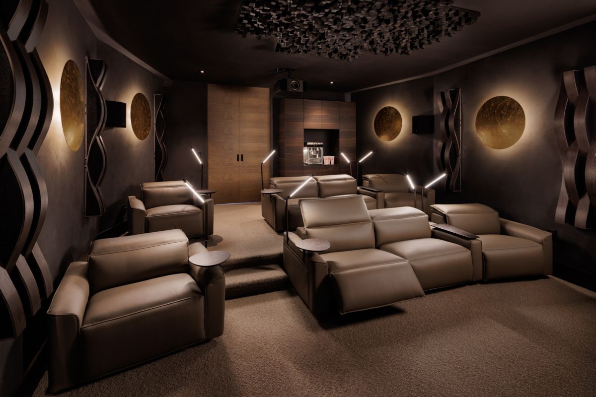 Interior of a movie theatre room in a luxury home mansion in Kelowna. Dimly lit interior with King Living lounge chairs.