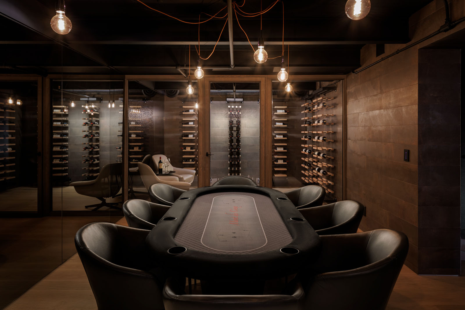 Dark and moody architectural interior of a residential wine cellar and poker room