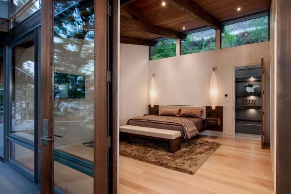 West Coast contemporary guest house looking into luxury architectural bedroom from outside