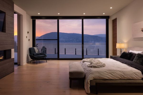 Luxury residential interior master bedroom and view of lake at sunset