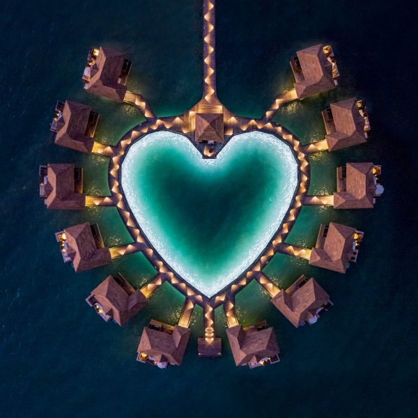 Aerial view at night of overwater bungalows for Sandals Resorts in the caribbean