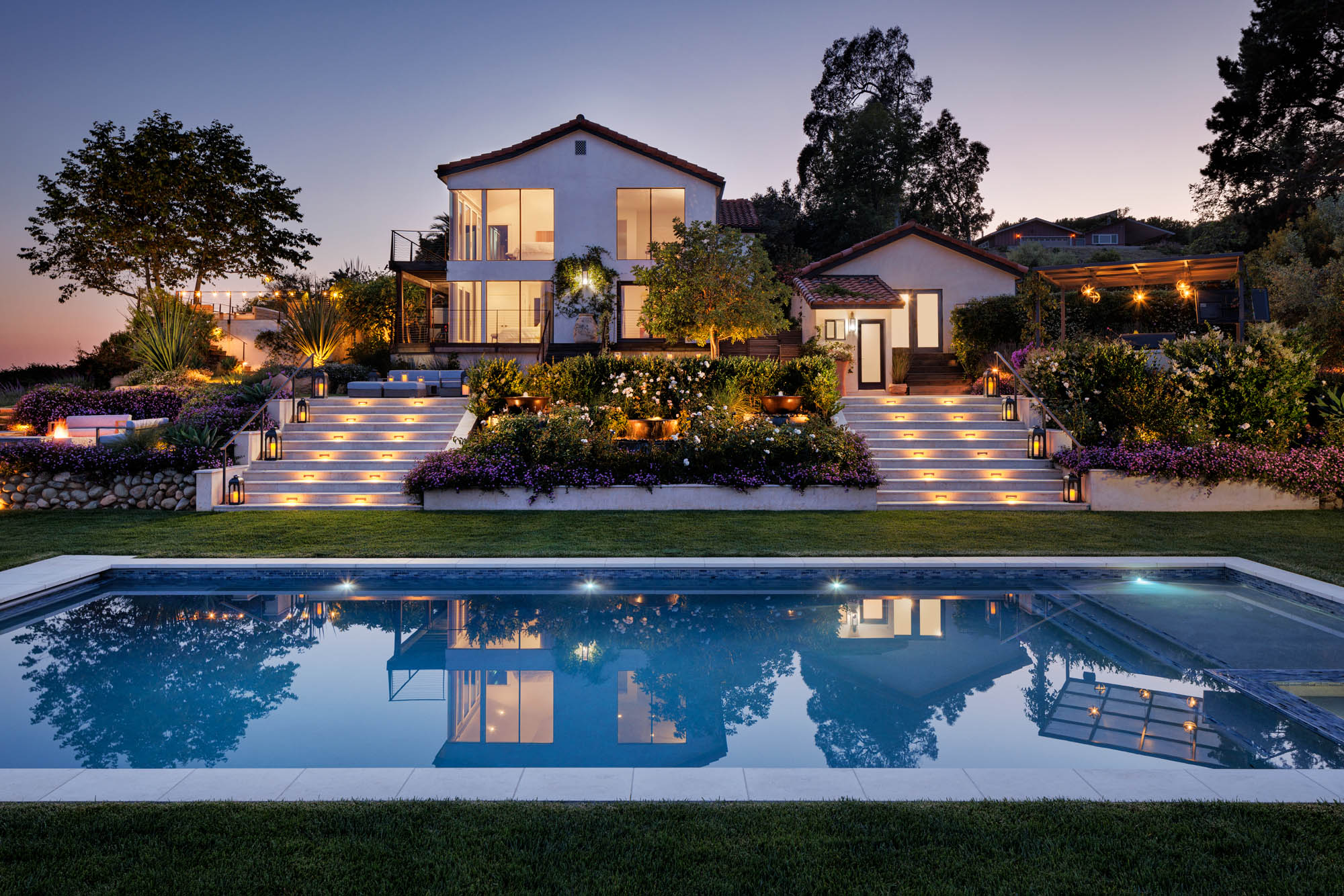 Luxury Malibu mansion with pool and terraced landscape architecture at dusk