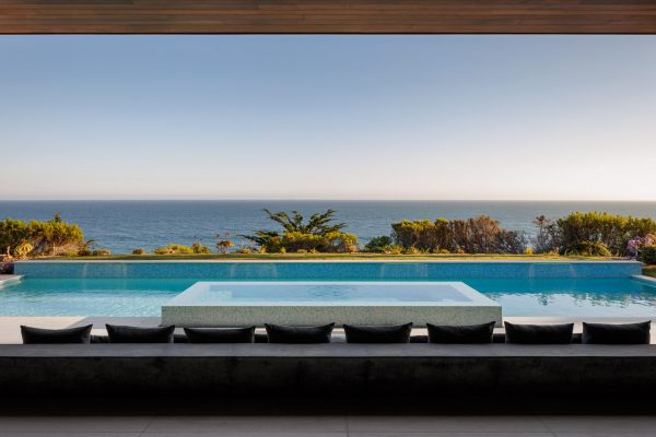 View over large couch and pool to Pacific ocean at Malibu luxury residence